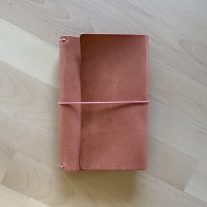 Trifold leather journal with a stitched pocket on the left