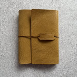 Trifold leather journal with a stitched pocket on the left