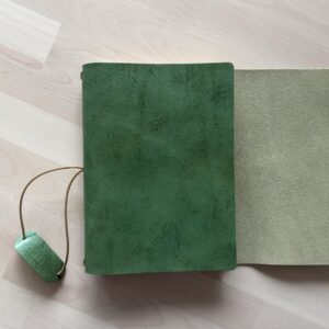 Trifold leather journal with a stitched pocket on the right