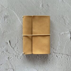 Trifold leather journal with a stitched pocket on the left