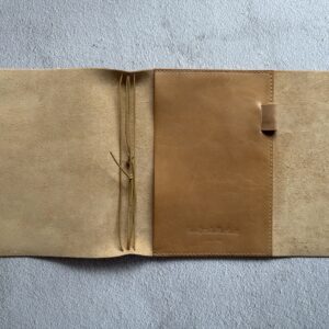 Trifold leather journal with a stitched pocket on the right