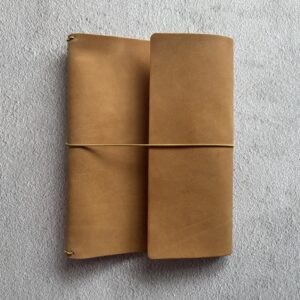 Trifold leather journal with a stitched pocket on the right